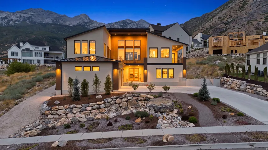 Contemporary architectural style with a flat roofline, multi-pane windows, and a prominent balcony