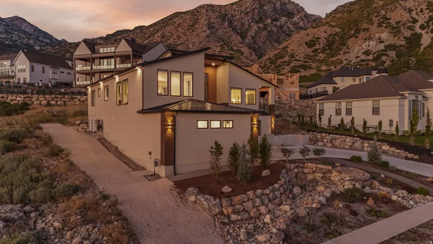 Contemporary architectural design with a sloped roofline, multiple windows, and exterior wall sconces
