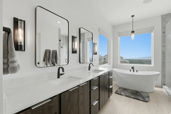 Dual vanity with integrated sinks, dark wood-finish cabinetry, and matte black fixtures