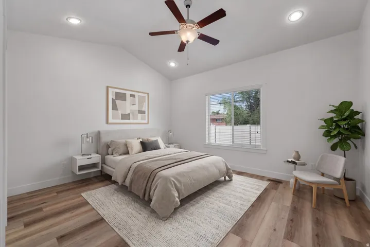 Vaulted ceiling with recessed lighting and ceiling fan, wood-finish flooring, and a large window with blinds