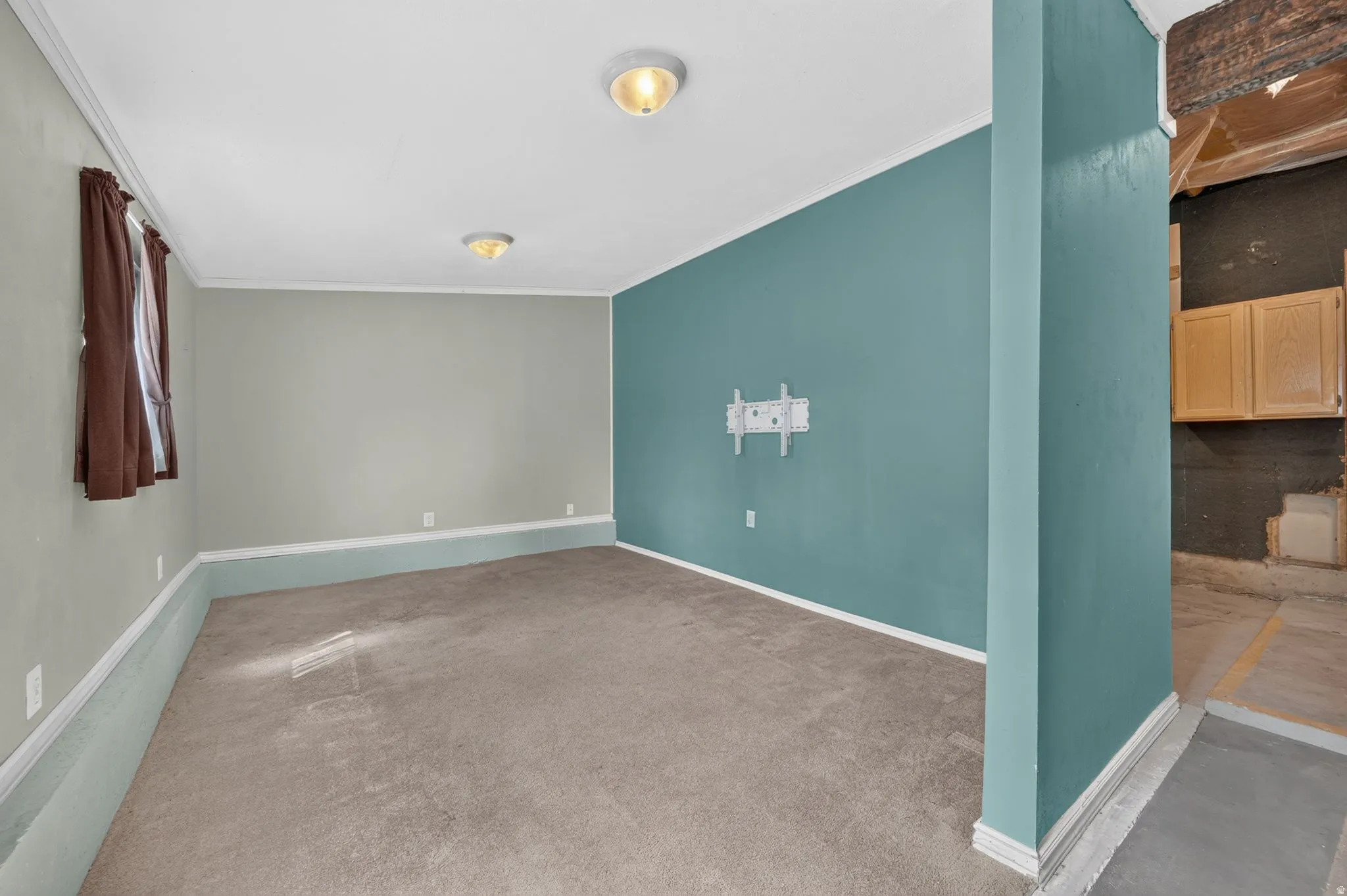Carpeted flooring with painted walls, multiple light fixtures, and a window