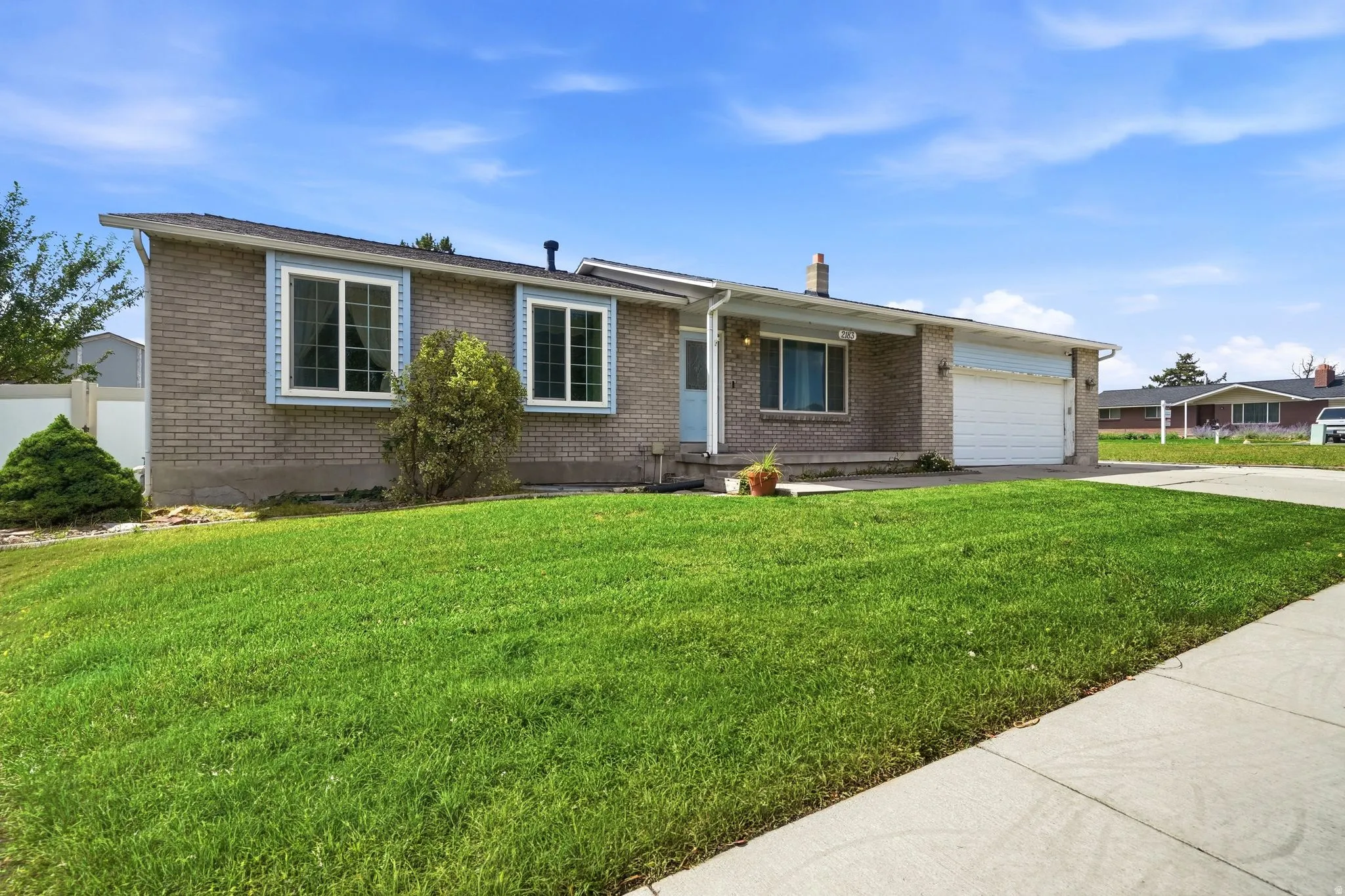 Brick exterior with a single-car garage, concrete driveway, and a front lawn