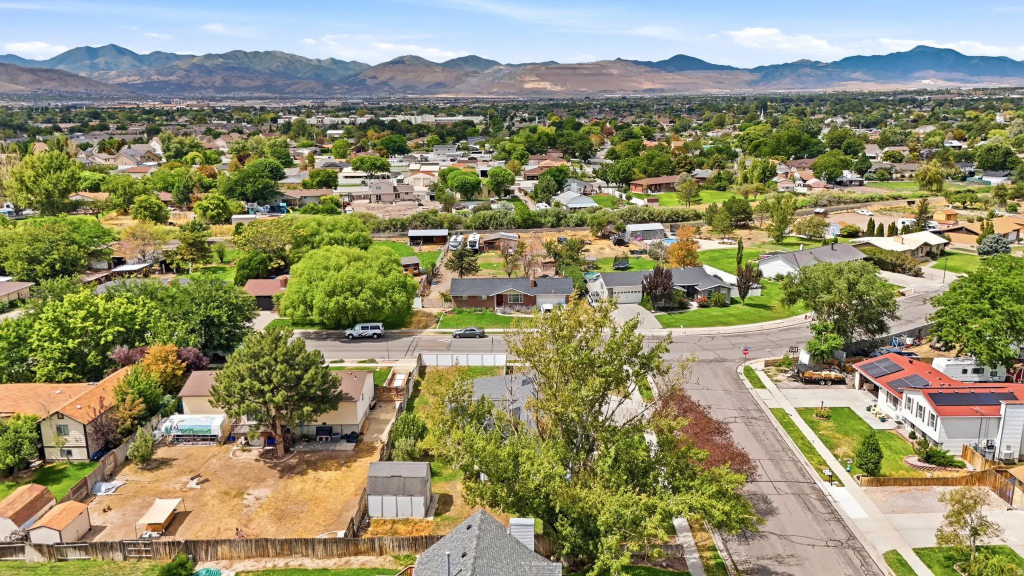 Residential neighborhood with established trees and mountain backdrop
