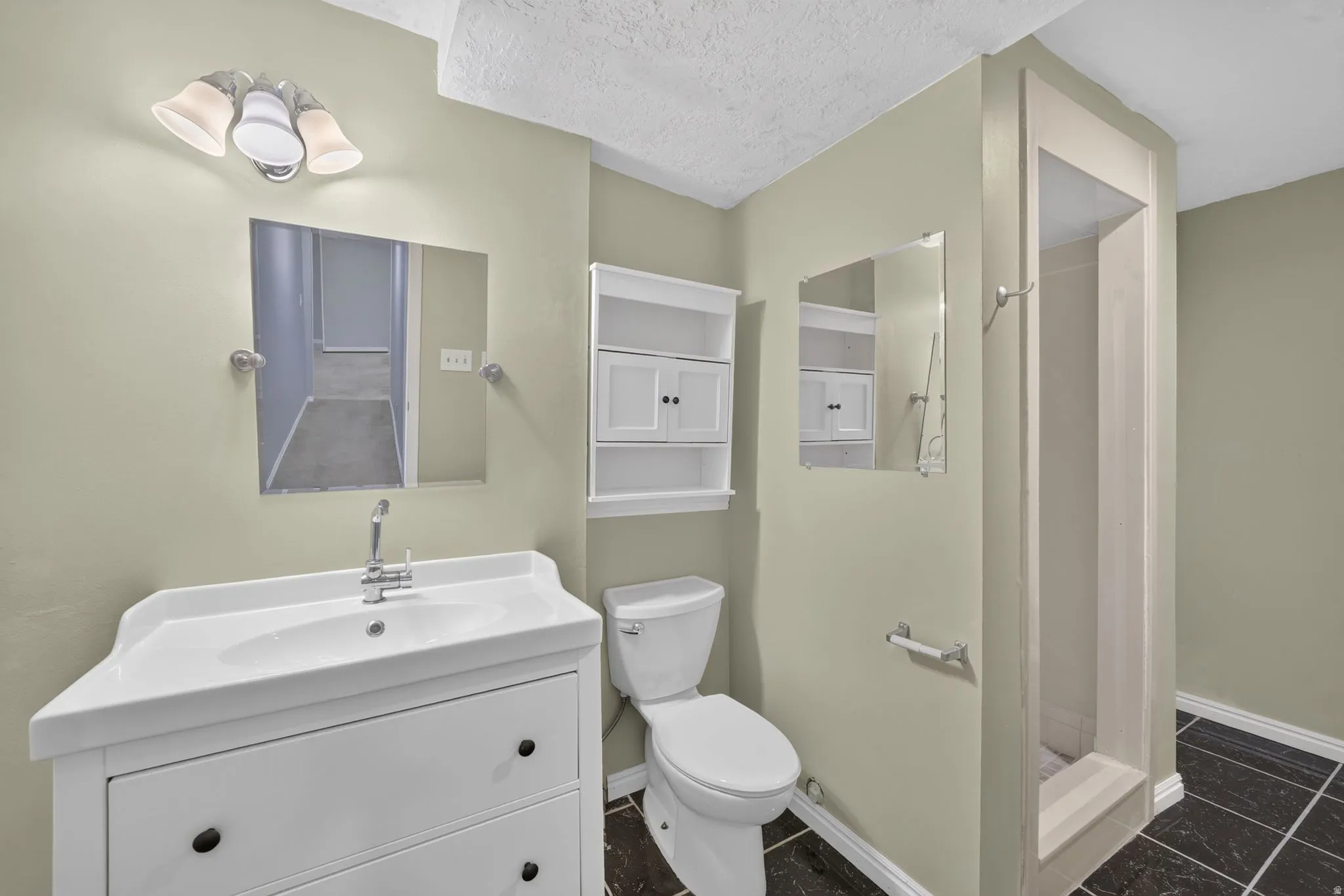 White vanity with an integrated sink, polished chrome faucet, and rectangular wall mirror