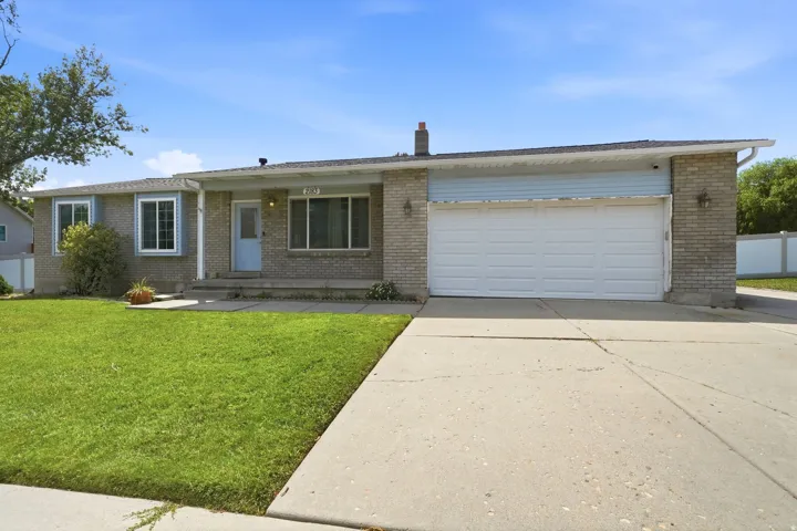 Brick exterior with light blue accents, a two-car garage, and a concrete driveway