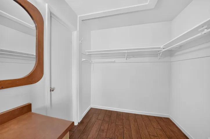 Hardwood-style flooring and built-in shelving with hanging rods