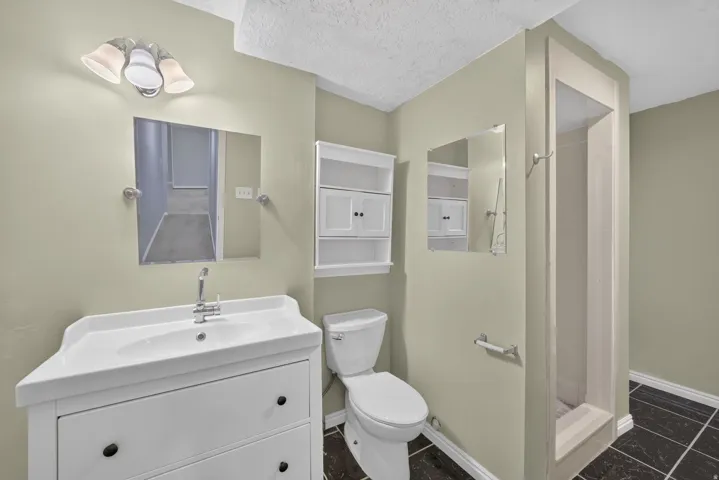 White vanity with an integrated sink, polished chrome faucet, and rectangular wall mirror