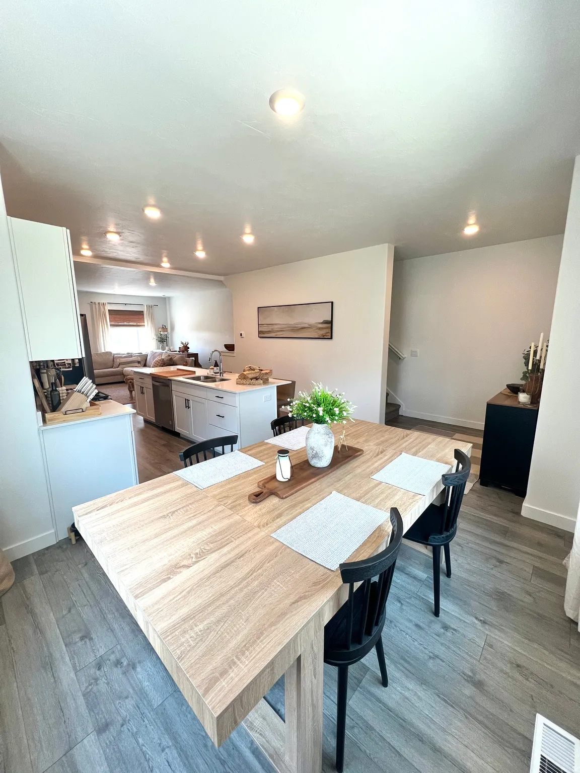 Open concept layout featuring wood-finish flooring, recessed lighting, a kitchen island with a white countertop, and white cabinetry