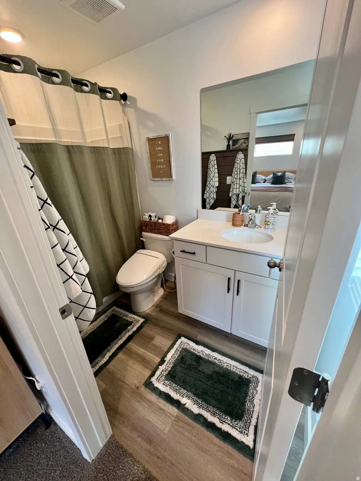 White vanity with dark hardware, undermount sink, and light countertop