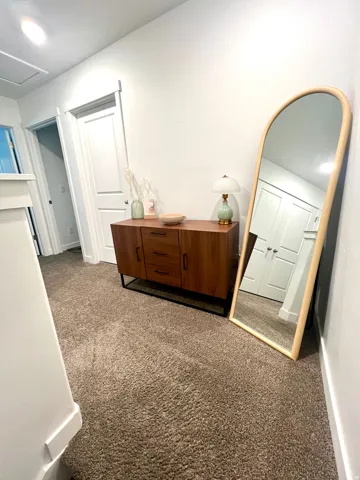 Soft carpet flooring, crisp white walls, and a recessed ceiling light