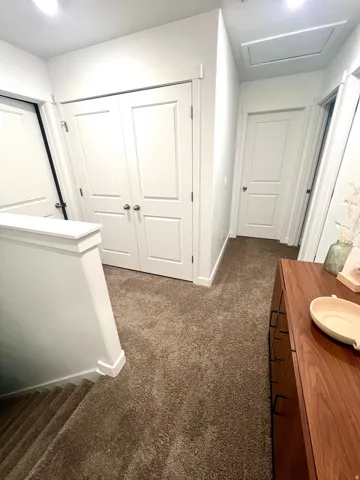 White paneled doors, neutral carpet, and a wooden console