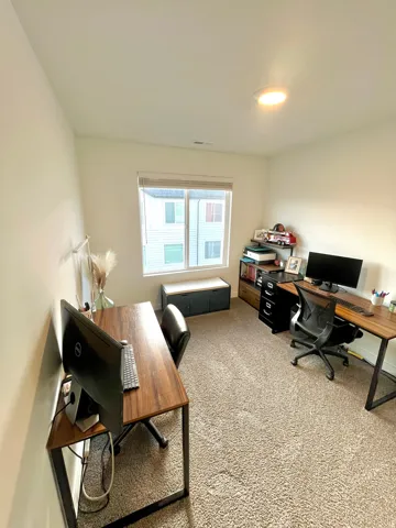 Plush carpet flooring and a window with blinds