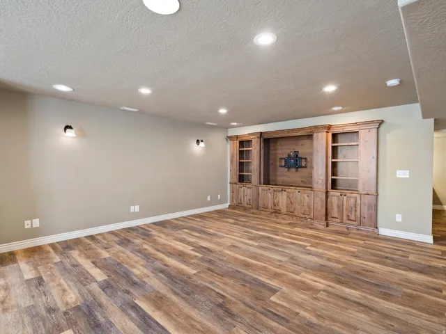 Wood-finish flooring with recessed lighting and sconces
