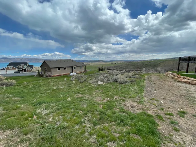 Expansive undeveloped lot with natural landscaping, featuring distant water and mountain scenery