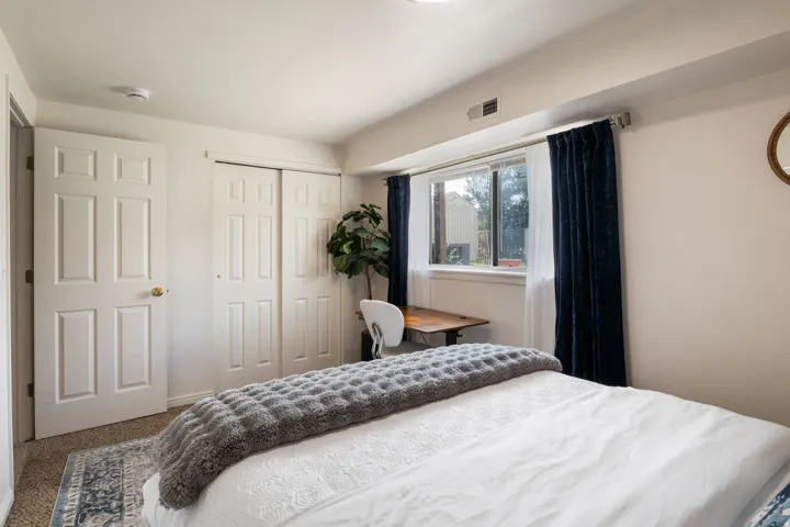White paneled doors, sliding closet doors, and a window with white trim