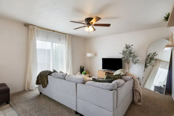 Recessed lighting, ceiling fan with integrated lighting, wood-finish console, and light-colored walls