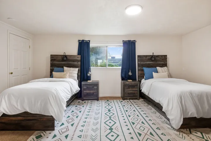 Recessed lighting, wood-finish bed frames, distressed wood-finish headboards, and a window with curtains