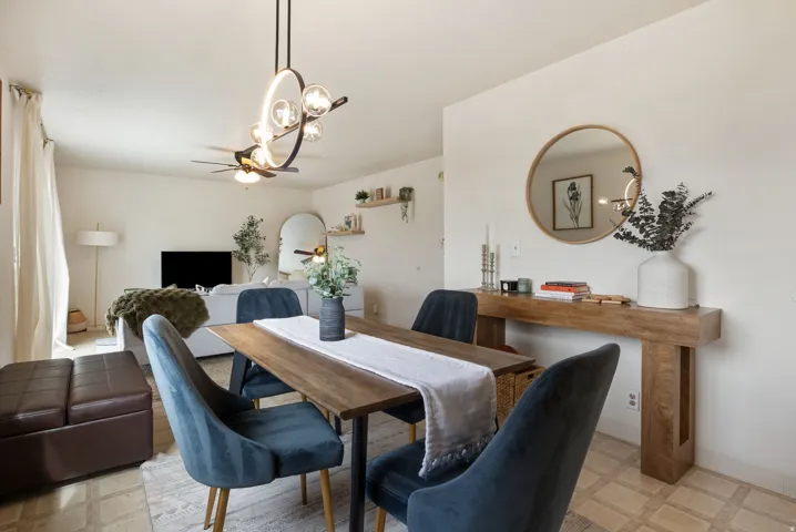 Dining area featuring a wood-finish table, a contemporary ceiling light fixture, and tile flooring