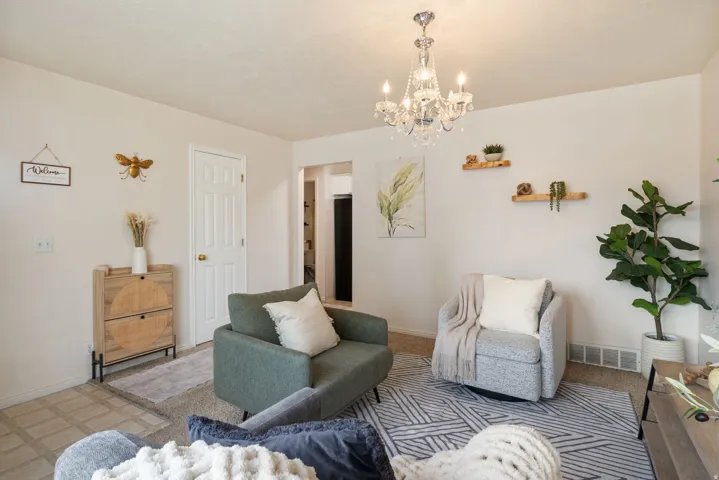 Neutral wall color, crystal chandelier, two floating wood shelves, built-in baseboard heating, wood-finish flooring