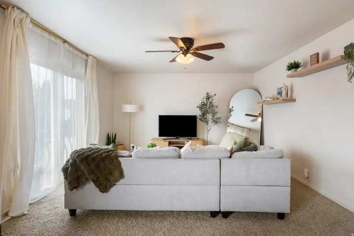 Ceiling fan with integrated lighting, glass sliding door, and floating wall shelves