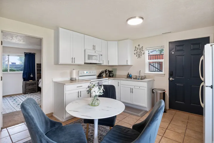 Kitchen featuring white cabinetry, light countertops, and a full suite of appliances