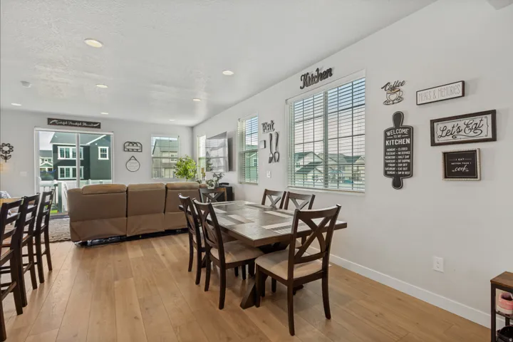 Open-concept living area with light wood-finish flooring, recessed lighting, and ample natural light from multiple windows
