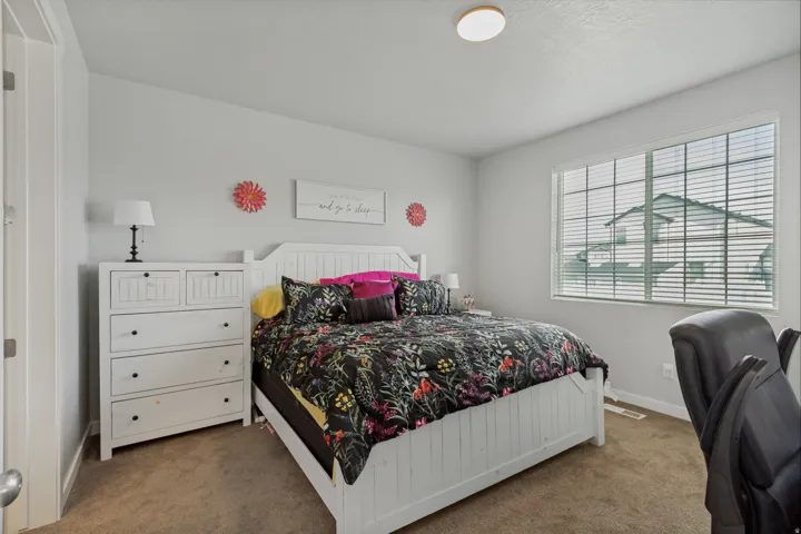 Bedroom with neutral carpet flooring, a large window, and a flush-mount ceiling light fixture