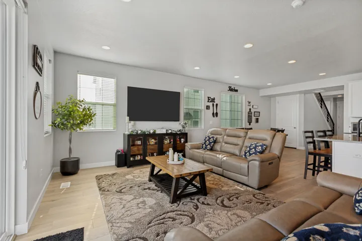 Light wood-finish flooring throughout, recessed ceiling lighting, and a neutral wall palette