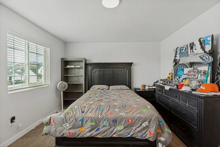 Window with horizontal blinds, built-in bookshelf, and overhead lighting