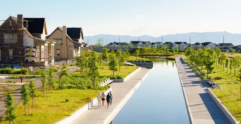 Waterfront setting with concrete pathways and mature landscaping