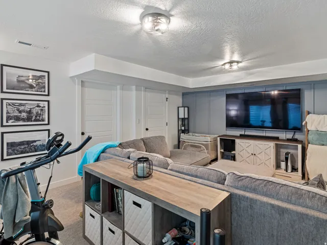 Recessed ceiling beam, two flush-mount ceiling lights, light-colored carpeting, white panel doors, and a blue accent wall with wall molding