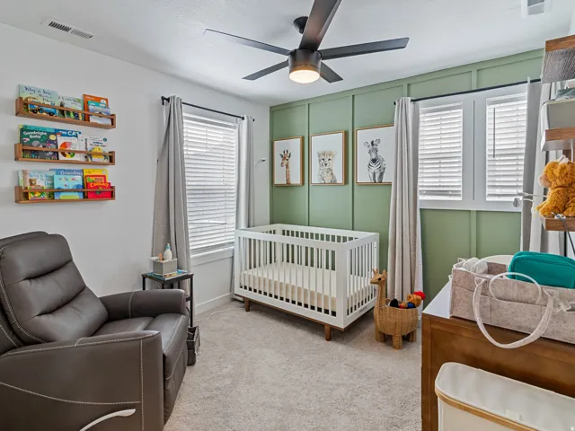 Recessed lighting, ceiling fan with integrated light, two windows with blinds, wall with vertical paneling, and wall-mounted shelving