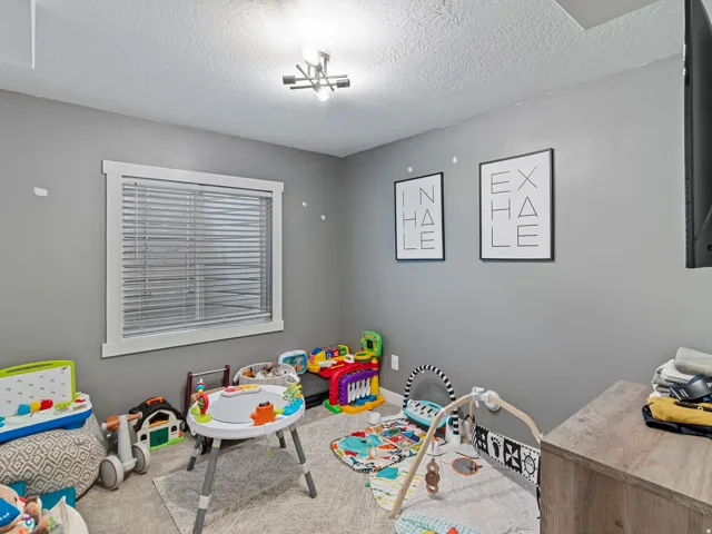 Window with horizontal blinds, recessed ceiling light fixture, textured ceiling, and gray wall paint