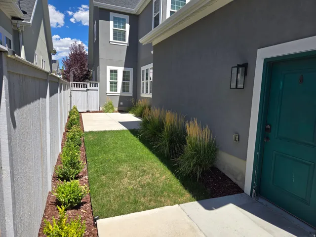 Stucco exterior with a teal entry door and a black wall lantern