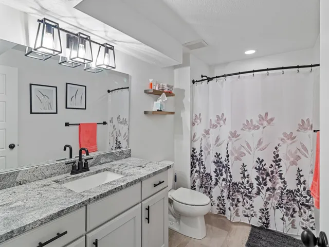 Vanity with a granite countertop, undermount sink, and matte black faucet