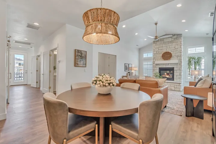 Wood-finish flooring throughout, vaulted ceiling, recessed lighting, stone-clad fireplace with mantel, and a ceiling fan