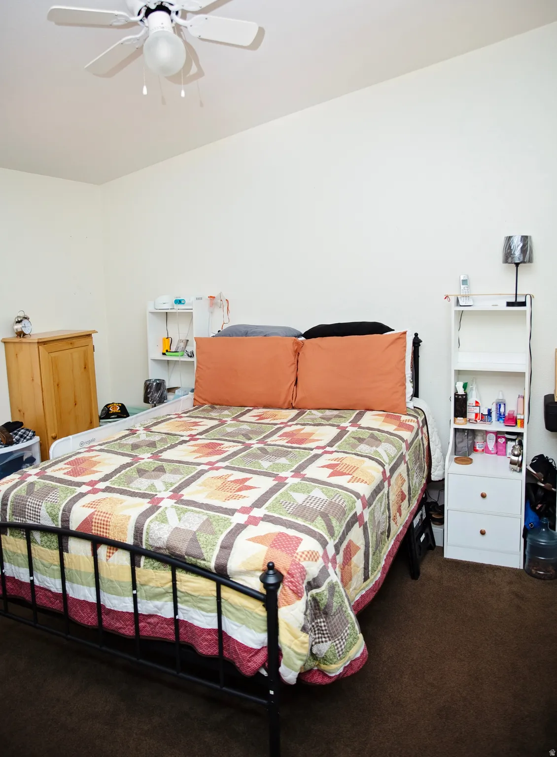 Angled ceiling, ceiling fan with integrated lighting, and carpeted flooring