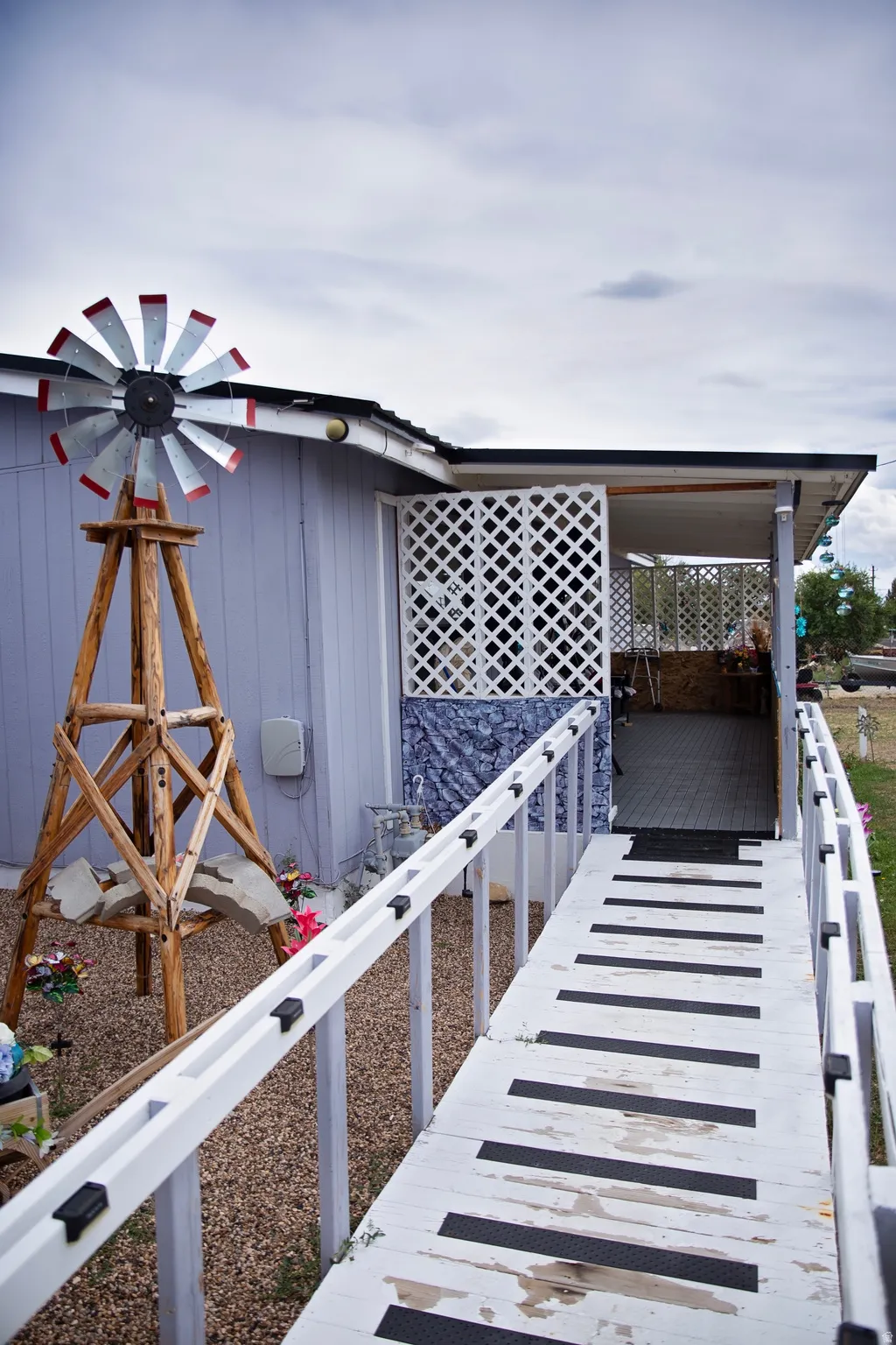 Exterior featuring a covered porch, white lattice accents, and a ramp entry