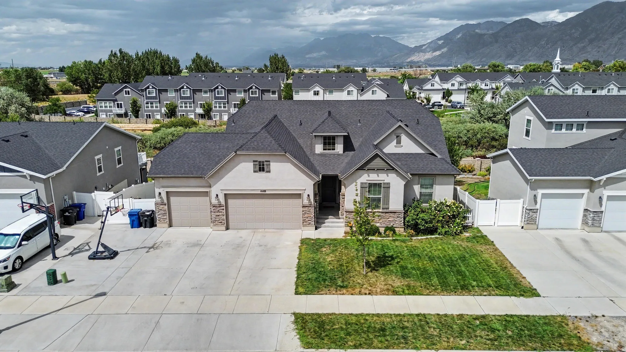 Two-story residence featuring a two-car garage, an additional single-car garage, and a peaked roofline