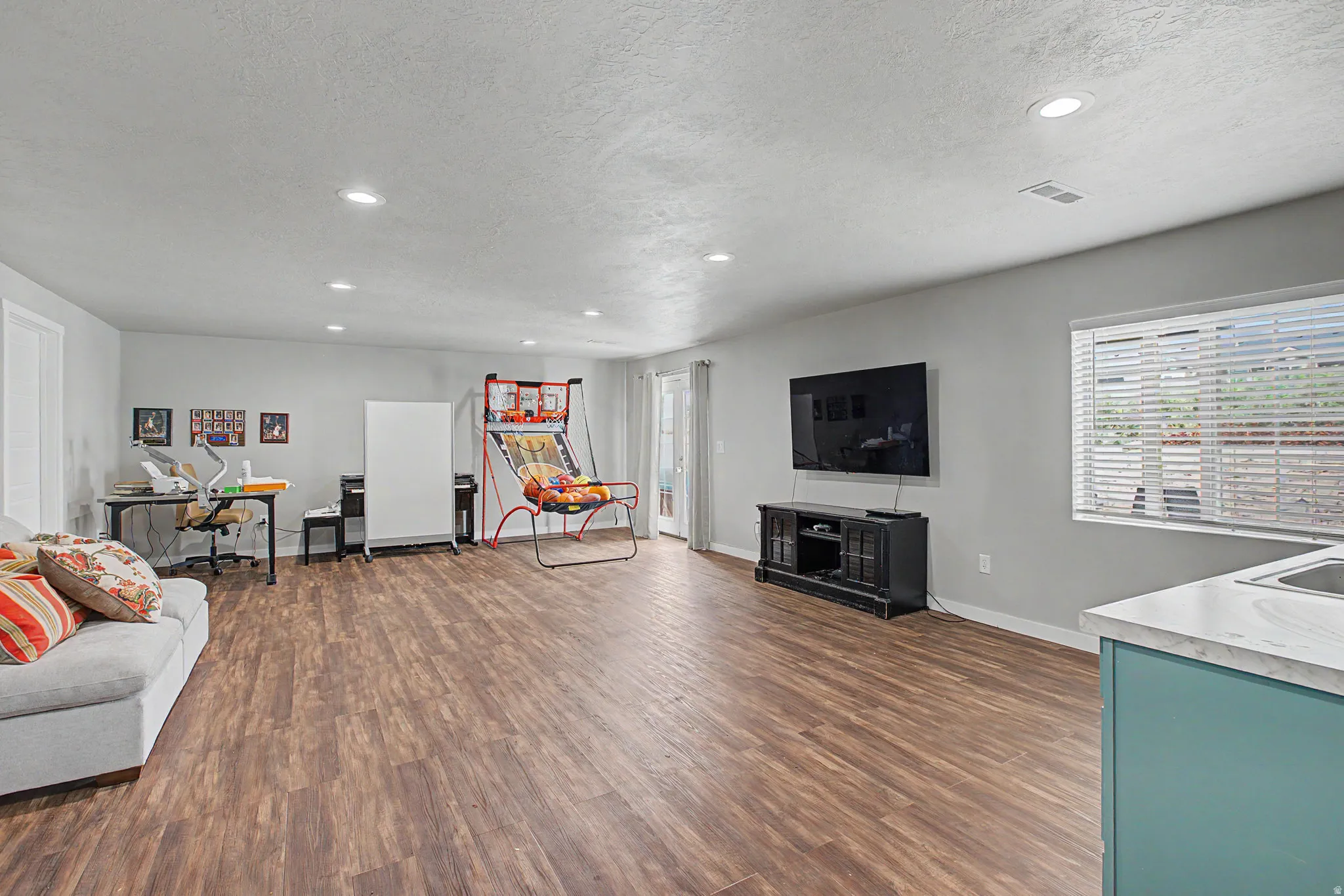 Recessed lighting, wood-finish flooring, white walls, and a window with blinds