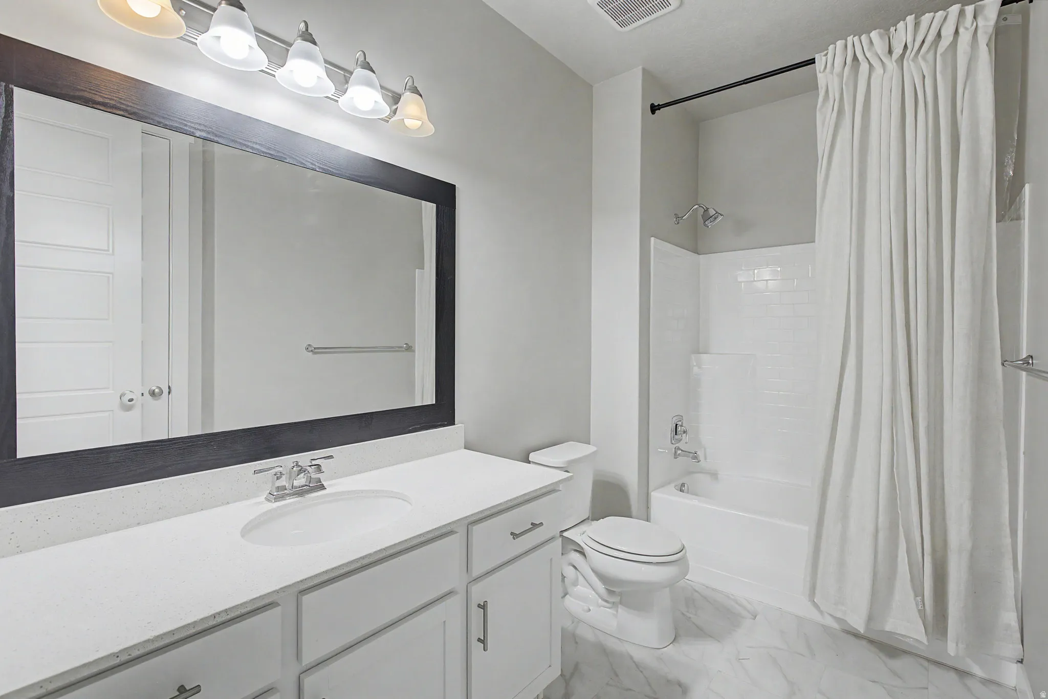 Vanity with white countertop, undermount sink, and chrome faucet