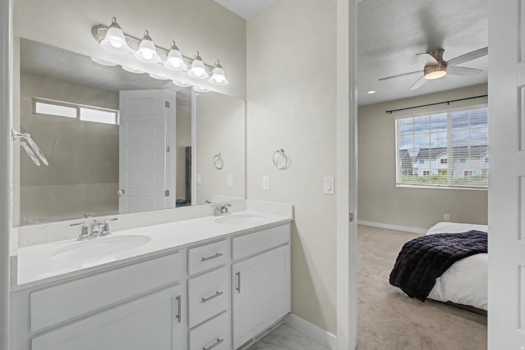 Dual vanity with integrated sinks, white cabinetry, and brushed nickel hardware