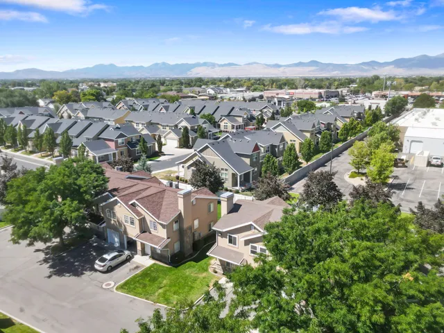 Residential community featuring varied architectural styles, mature trees, and mountain scenery