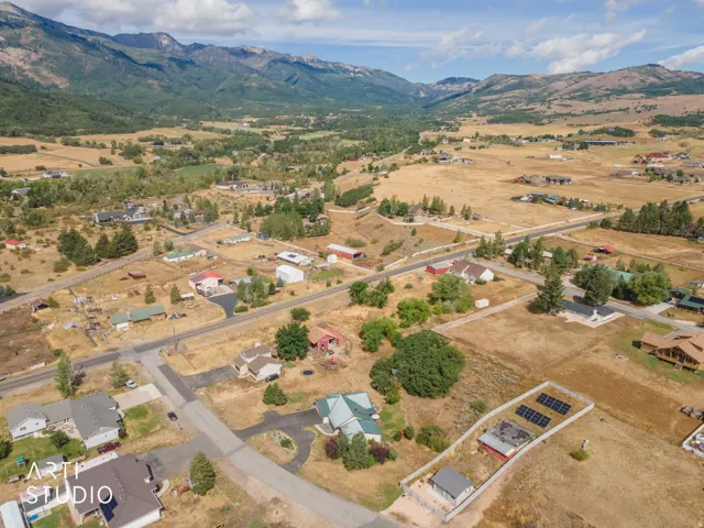 Expansive property featuring a solar array, fenced perimeter, and several outbuildings