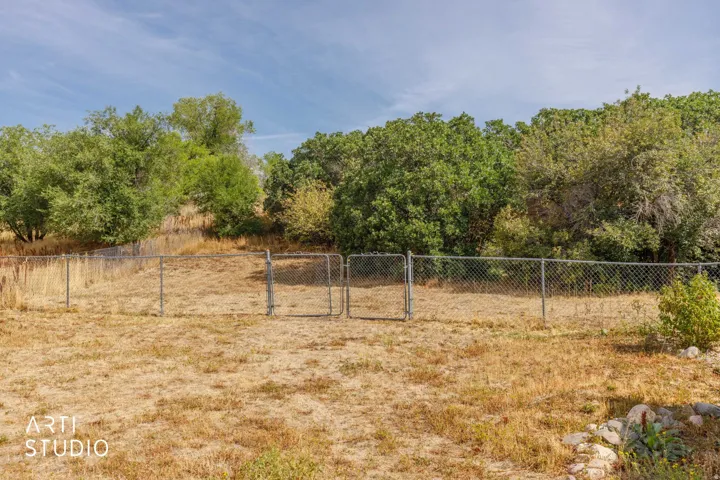 Fenced yard with natural landscaping and mature trees