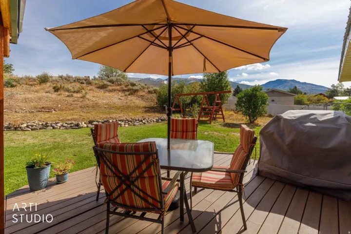 Expansive outdoor deck with wood-finish planks and a manicured lawn