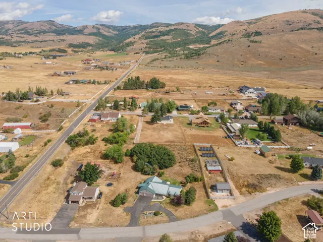 Expansive rural setting with mountain backdrop and residential properties