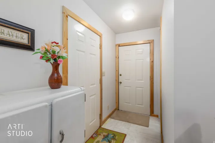 Entryway featuring two paneled doors with natural wood trim and a flush-mount ceiling light