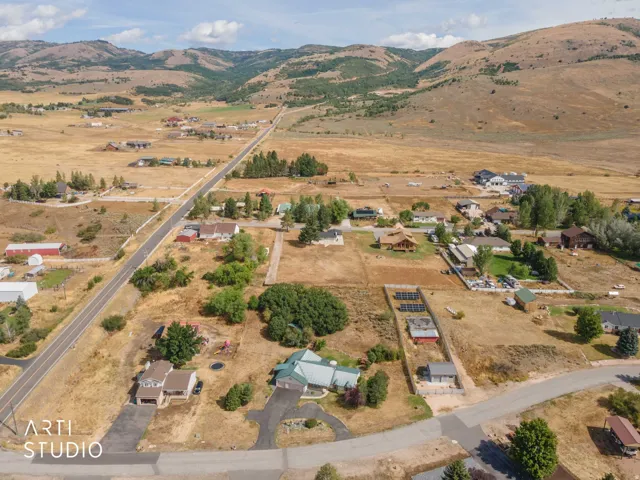 Expansive rural setting with mountain backdrop and residential properties