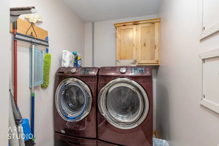 Laundry area with overhead wood cabinetry